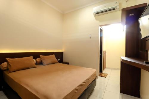 a bedroom with a bed and a television in it at Hotel Bungurasih Syariah in Bungurasih