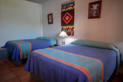 two beds in a hotel room with blue sheets at Hotel Posada Luna Sol in La Paz