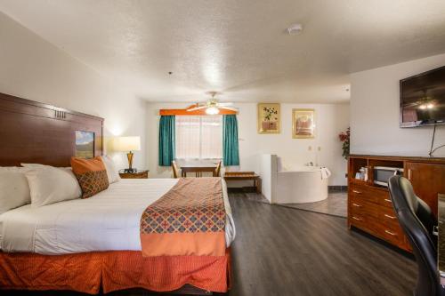 a hotel room with a bed and a bathroom at Sandia Peak Inn, a Howard Johnson by Wyndham in Albuquerque