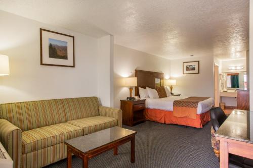 a hotel room with a bed and a couch at Sandia Peak Inn Old Town ABQ, a Howard Johnson by Wyndham in Albuquerque