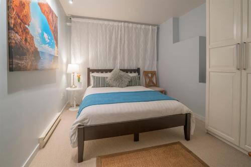 a bedroom with a bed and a painting on the wall at Coastal Fox Den in Sechelt
