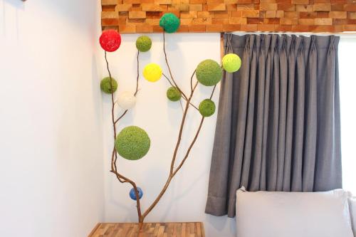 a room with a branch with balloons on the wall at Summerflow Hostel in Xiaoliuqiu