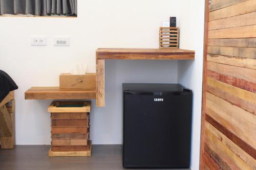 a small black refrigerator sitting next to a shelf at Summerflow Hostel in Xiaoliuqiu