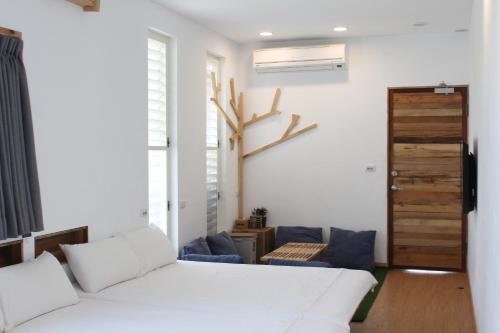 a bedroom with a white bed and a blue couch at Summerflow Hostel in Xiaoliuqiu
