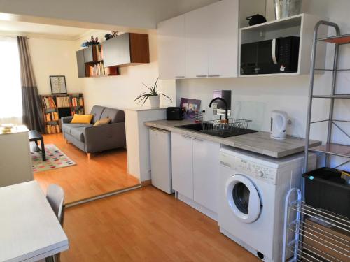 une cuisine et un salon avec une machine à laver dans l'établissement Appartement proche de Paris comme à la maison, à Cormeilles-en-Parisis