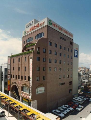 un gran edificio con coches estacionados en un estacionamiento en New Gifu Hotel Plaza en Gifu