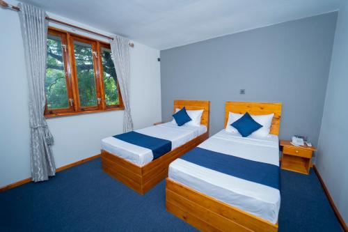 1 dormitorio con 2 camas y ventana en Havana Club Resort en Trincomalee
