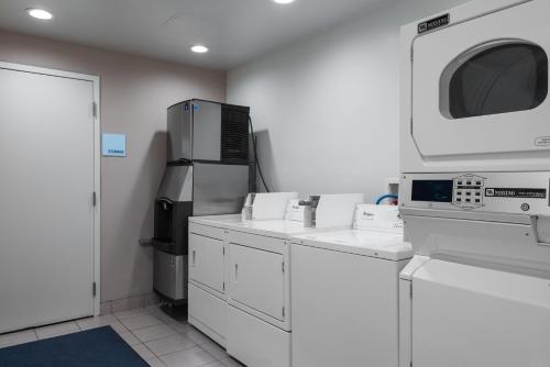 a kitchen with white cabinets and a microwave at Holiday Inn Express Lathrop - South Stockton, an IHG Hotel in Lathrop