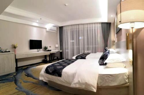 a bedroom with a large bed and a desk at Demei Boutique Hotel in Kunming