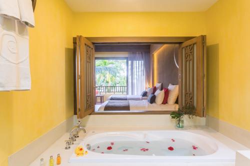 a large bath tub in a room with a bedroom at New Star Beach Resort in Chaweng Noi Beach