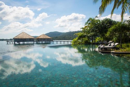 a large pool of water with a pier and boats at Song Saa Private Island in Song Saa Private Island
