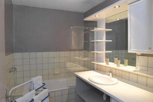 une salle de bain avec un lavabo et un miroir dans l'établissement Les ARTISANS au centre historique, à Colmar