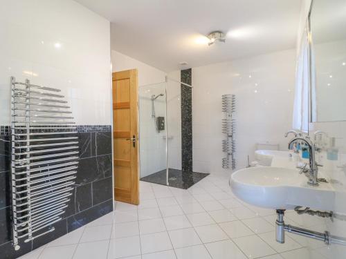 a white bathroom with a sink and a shower at Manor House in Chesterfield