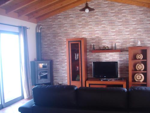 un soggiorno con un divano e un muro di mattoni di Casa da Caixeira ad Arco da Calheta