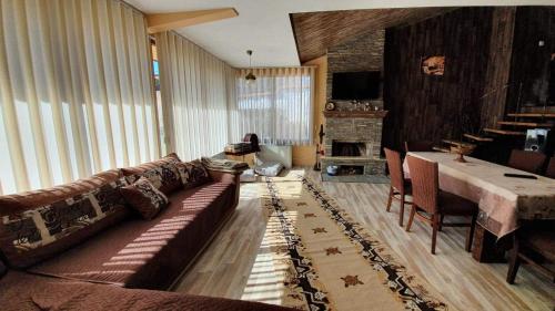 un soggiorno con divano e tavolo di Къща За Гости Уют Guest House Cozy a Starosel