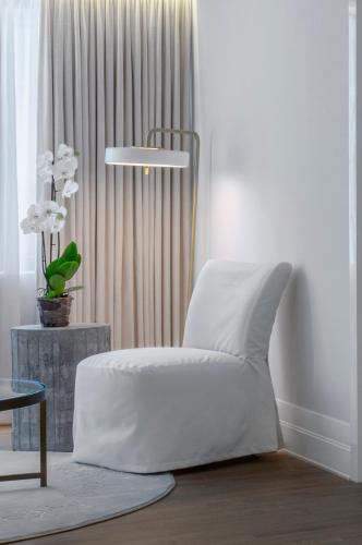 a white chair in a room with a window at The Merchant House in Manama