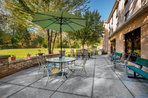 a patio with a table and chairs and an umbrella at Holiday Inn Express Hotel & Suites Canton by IHG in Canton