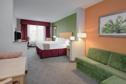 une chambre d'hôtel avec un lit et un canapé dans l'établissement Holiday Inn Express Hotel & Suites Clute-Lake Jackson, an IHG Hotel, à Clute