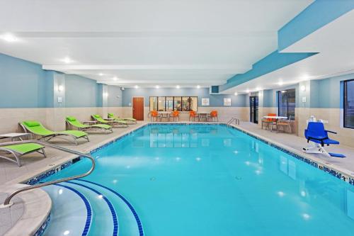a pool in a hotel room with chairs and tables at Holiday Inn Express & Suites Culpeper by IHG in Culpeper