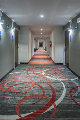 a long hallway with red hose painted on the floor at Holiday Inn Express & Suites Chihuahua Juventud by IHG in Chihuahua