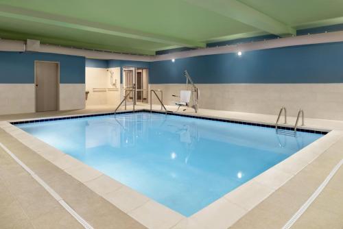 a large swimming pool with blue water in a building at Holiday Inn Express & Suites - Cincinnati South - Wilder by IHG in Wilder