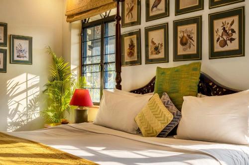 a bedroom with a bed with pillows and pictures on the wall at Gorayya Villa in Dehradun