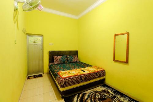 a bedroom with a bed in the corner of a room at Willy Homestay Borobudur in Borobudur