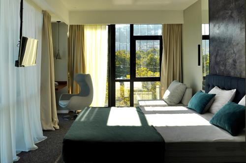 a hotel room with two beds and a large window at River View Hotel Tbilisi in Tbilisi City
