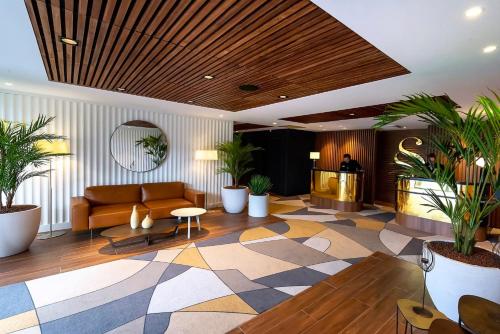 a lobby with a couch and a table and plants at Servotel Saint-Vincent in Nice