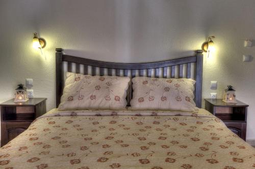 a bedroom with a bed with pillows and two lamps at Toula Rooms in Ángistron