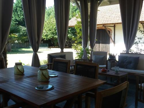 d'une table et de chaises dans un restaurant avec fenêtre. dans l'établissement Les Eygletières, à Bourriot-Bergonce