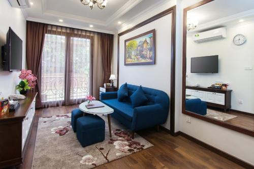 a living room with a blue couch and a table at Hanoi Central Hotel & Residences in Hanoi