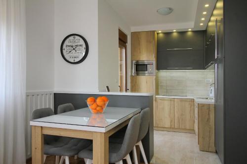 una cucina e una sala da pranzo con tavolo e sedie di Apartman Prime West a Zlatibor
