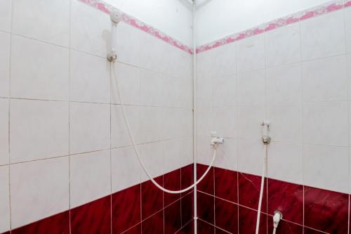 a bathroom with a red and white tiled wall at Adinda Beach Hotel and Villa in Bantul