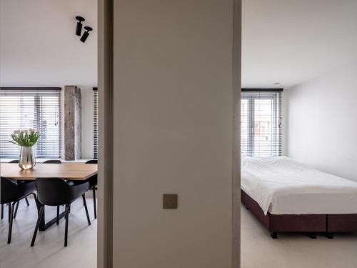 een slaapkamer en eetkamer met een bed en een tafel bij Maison N in Gent