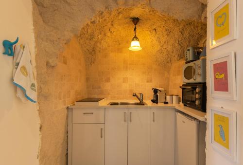 a small kitchen with a sink in a stone wall at Sapir Boutique Apartments in Beer Sheva