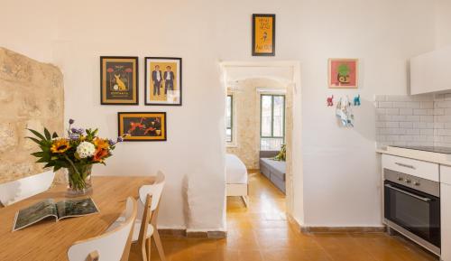 a kitchen and dining room with a vase of flowers on a table at Sapir Boutique Apartments in Beer Sheva