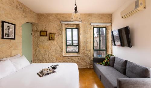 a living room with a bed and a couch at Sapir Boutique Apartments in Beer Sheva