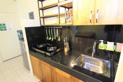 a kitchen with a sink and a counter top at Queen Victoria Apartment Batam in Batam Center