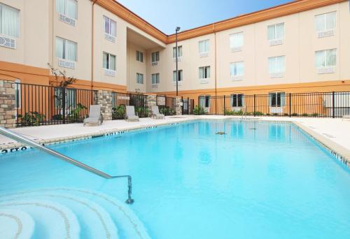 una grande piscina di fronte a un edificio di Holiday Inn Express Hotel & Suites Marshall, an IHG Hotel a Marshall