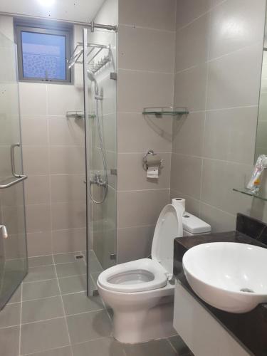 La salle de bains est pourvue de toilettes, d'un lavabo et d'une douche. dans l'établissement Căn hộ 3PN Gold View, 346 Bến Vân Đồn, Phường 1, Q4, HCM, à Hô-Chi-Minh-Ville