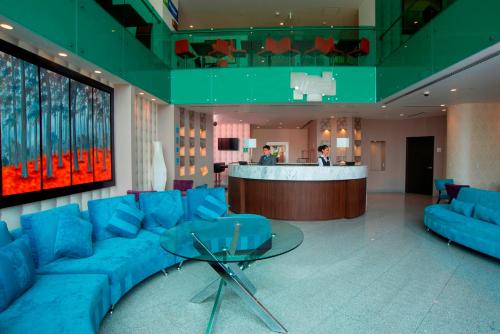 a lobby with a blue couch and a bar at Holiday Inn Express & Suites Queretaro by IHG in Querétaro