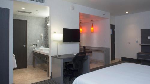 a hotel room with a bed and a desk and a sink at Holiday Inn Express & Suites Queretaro by IHG in Querétaro