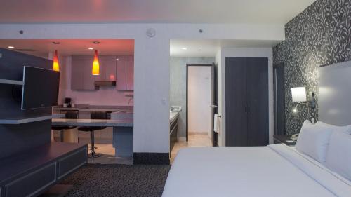 a hotel room with a bed and a kitchen at Holiday Inn Express & Suites Queretaro by IHG in Querétaro