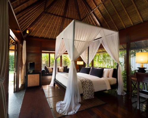 a bedroom with a bed with a canopy at Kayumanis Jimbaran Private Villas & Spa in Jimbaran
