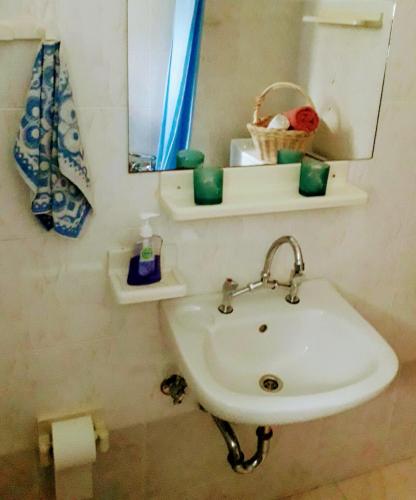 a white sink in a bathroom with a mirror at Green House in Karistos