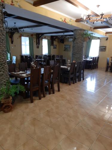 a dining room with wooden tables and chairs at Stara Vezha Hotel in Boryspilʼ