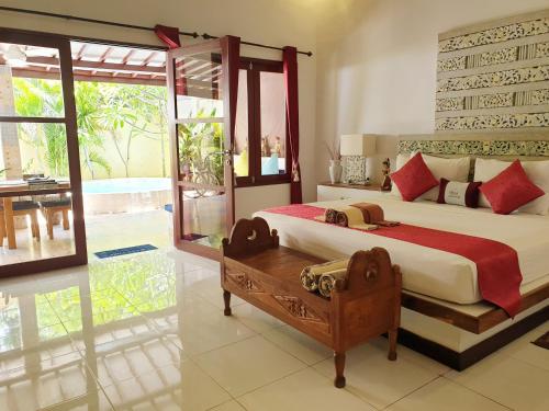 Un dormitorio con una cama grande y una ventana grande. en Cinta Cottages, en Gili Trawangan