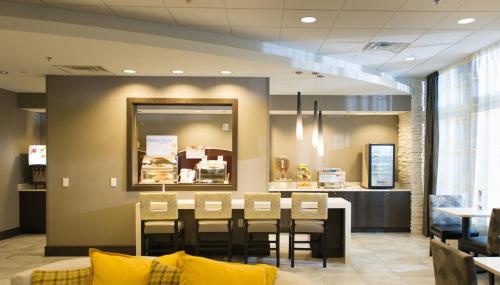 a restaurant with a table and chairs and a counter at Holiday Inn Express and Suites Madison Central by IHG in Madison