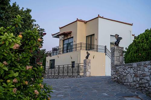 a large white house with a stone wall at Almyrida Village & Waterpark in Almirida